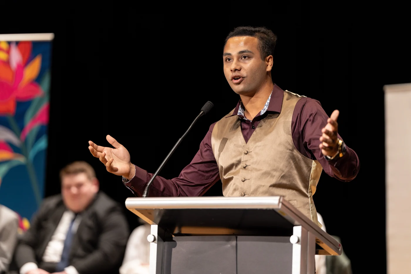 Nehal Nafcy speaking on stage to an audience